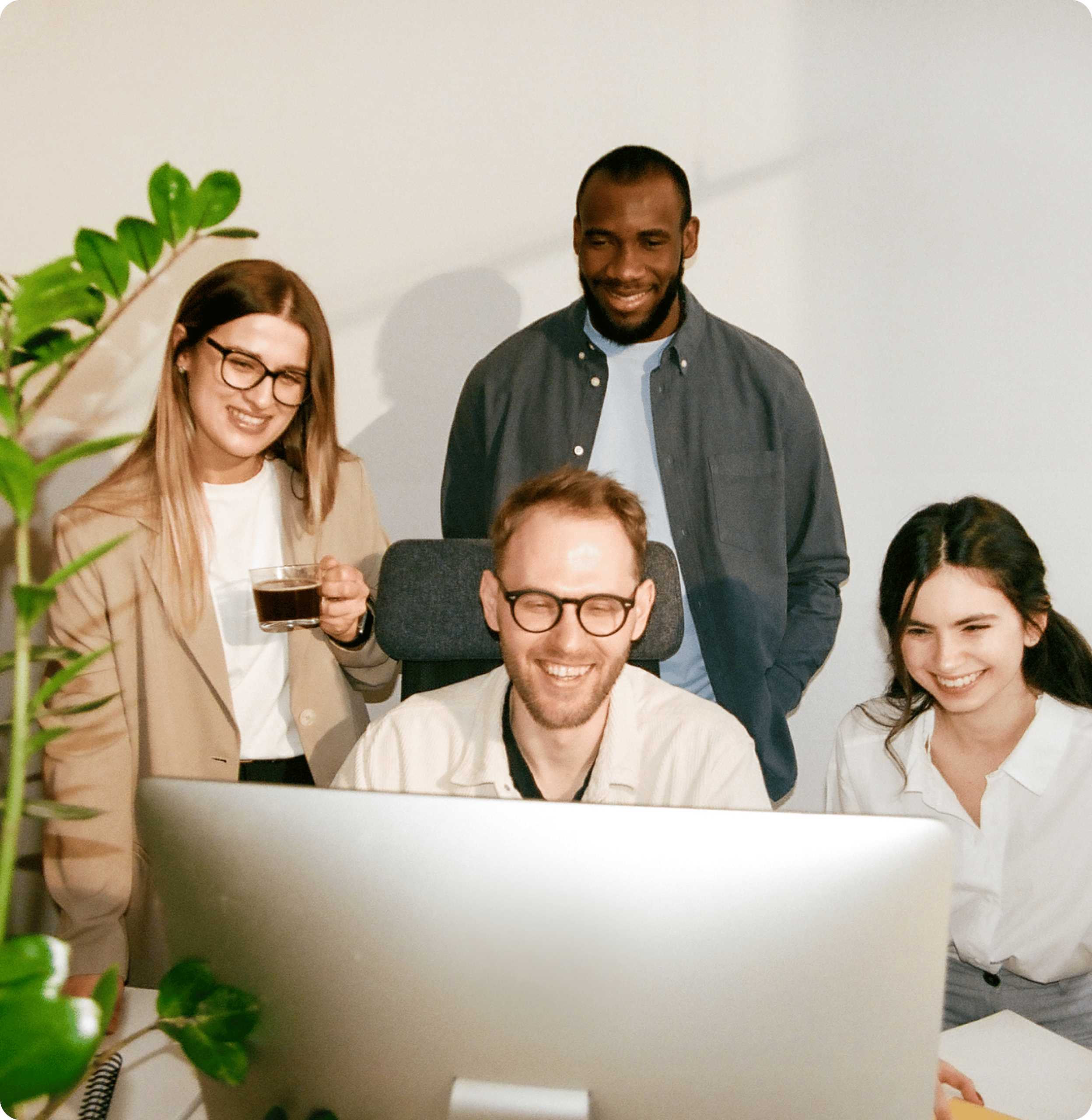 Colleagues gathered around a computer, positively engaged with something